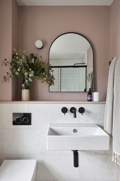 a white sink sitting under a mirror in a bathroom