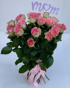 a bouquet of pink roses with the word mom written on it