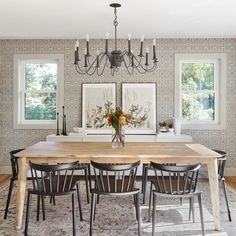 a dining room table with four chairs and a chandelier hanging from the ceiling