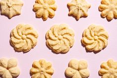 several cookies are arranged in the shape of flowers on a pink surface with white background