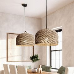 two chandeliers hanging over a wooden table in a dining room with white chairs