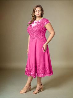 a woman in a pink dress posing for the camera with her hands on her hips