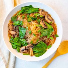 a white bowl filled with noodles and mushrooms