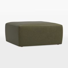 a green ottoman sitting on top of a white floor