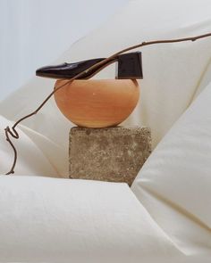 a wooden object sitting on top of a stone block next to a white sheet covered bed