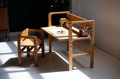 a wooden desk and chair in a room with sunlight coming through the window onto the floor