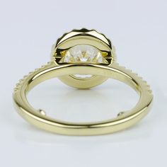 a yellow gold engagement ring set with a round brilliant cut diamond in the center, on a plain white background