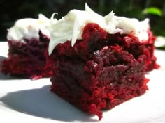 a piece of red velvet cake with white frosting