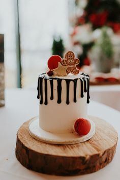 a white and black cake sitting on top of a wooden slice