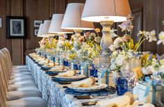 a long table with blue and white place settings