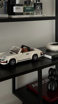 a toy car is sitting on top of a book shelf