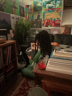 a woman sitting on a couch in front of a book shelf with books and magazines