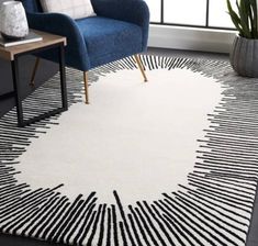 a white rug with black lines on it in a living room next to a blue chair