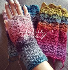 three crocheted fingerless gloves are sitting on the couch