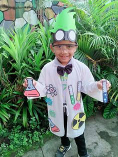 a young boy wearing a green hat and bow tie with science themed items on it