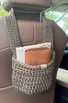 a car seat with a wallet in the back pocket and some other items sticking out of it