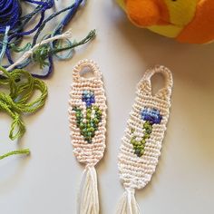 two crocheted key fobs sitting on top of a table next to a stuffed animal