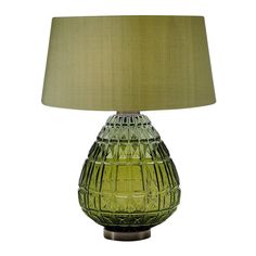 a green glass table lamp with a beige shade on it's base and a light brown fabric lampshade