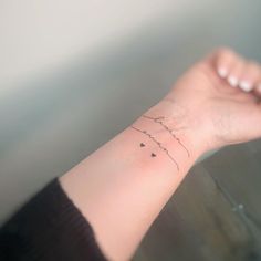 a woman's wrist tattoo with the word love written in cursive writing