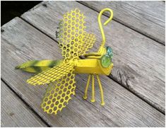 a yellow dragon made out of plastic sitting on top of a wooden table next to a string