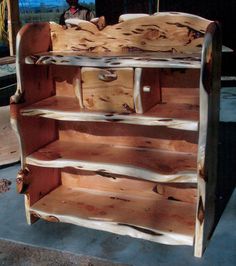 a shelf made out of wood sitting on top of a cement slab