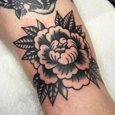 a black and white flower tattoo on the leg