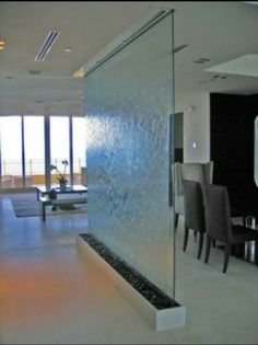 a living room filled with lots of furniture and walls covered in frosted glass doors