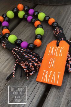 an orange tag that says trick or treat on it next to some black and white beads