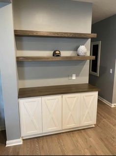 an empty room with some shelves on the wall