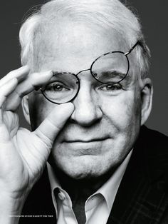 black and white photograph of an older man with glasses looking over his eyeglasses