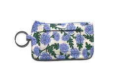 a blue and white flowered purse with a keychain hanging from the front