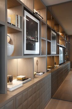 an empty room with wooden shelves and pictures on the wall, along with bookshelves