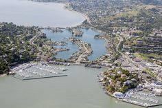 an aerial view of a marina with boats in the water and buildings on land around it