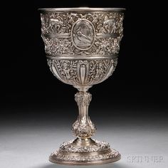 an ornate silver goblet on a black background