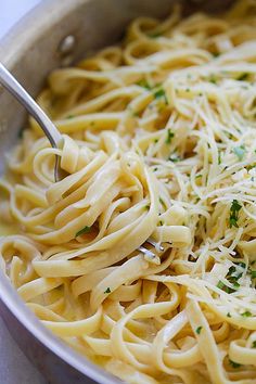 a large pot filled with pasta and parmesan cheese on the side, ready to be eaten