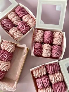 three boxes filled with pink and white frosted cookies