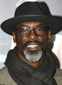 a man wearing glasses and a black hat