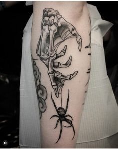 a woman's arm with a skeleton and spider on it