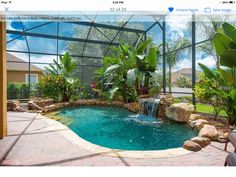 a pool with a waterfall in the middle of it and some plants on either side