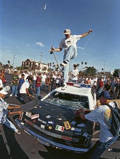 a man riding a skateboard on top of a car in front of a crowd