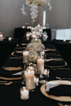 the table is set with candles, flowers and place settings for an elegant dinner party