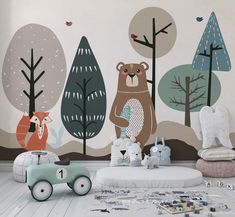 a child's room decorated with woodland animals and trees, including a teddy bear