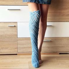 a woman's legs wearing blue socks and high heeled boots in the kitchen