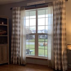 a living room with a large window and plaid curtains