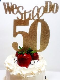 a white cake topped with a strawberry and the number 50