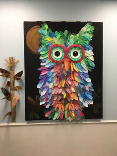 an owl made out of colored paper on a wall