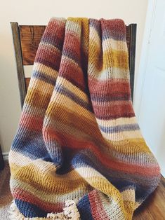 a striped blanket sitting on top of a wooden chair