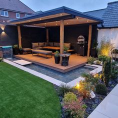 an outdoor living area is lit up with lights and lighting on the side of the house