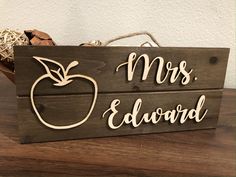 a wooden sign that says mr and mrs edward with an apple in the background on a table