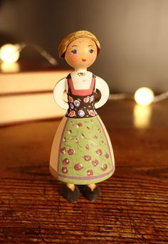 a small figurine is standing on a table with lights in the back ground